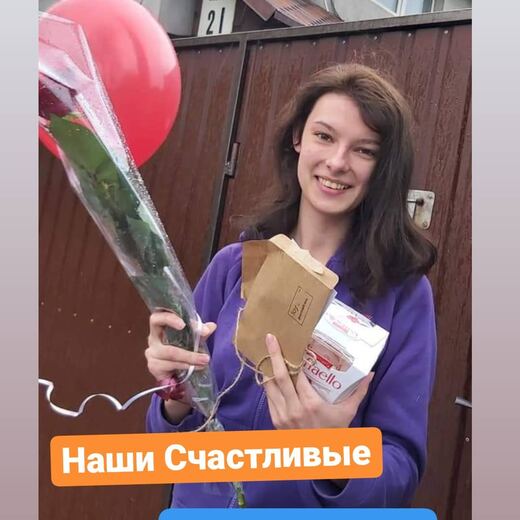 A recipient holding a delivered envelope and a rose.