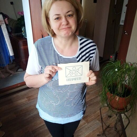 A recipient holding up a hand-stamped kraft envelope.