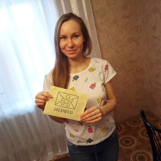 A recipient holding a delivered envelope by a window.